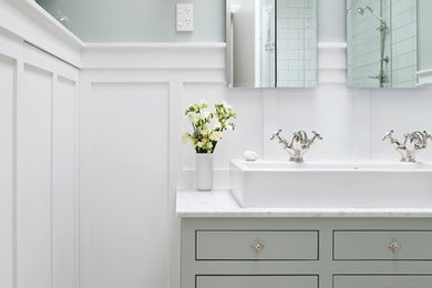 Small transitional master bathroom in Auckland with a trough sink, furniture-like cabinets, green cabinets, marble benchtops, a one-piece toilet, white tile, ceramic tile, green walls and porcelain floors.