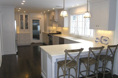 Inspiration for a mid-sized timeless dark wood floor eat-in kitchen remodel in New York with an undermount sink, shaker cabinets, gray cabinets, granite countertops, white backsplash, subway tile backsplash and stainless steel appliances