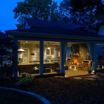 Covered outdoor area with fireplace, grill island and paver patio