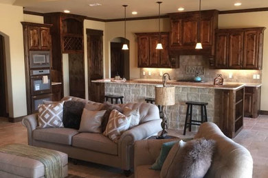 Inspiration for a mid-sized transitional l-shaped travertine floor open concept kitchen remodel in Dallas with an undermount sink, raised-panel cabinets, dark wood cabinets, granite countertops, beige backsplash, ceramic backsplash, stainless steel appliances and an island