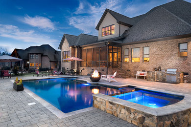 Example of a large classic backyard stone and rectangular lap hot tub design in Other