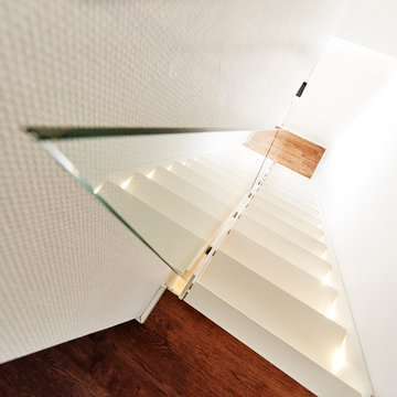 Treppe ganz in Weiß mit Glasgeländer