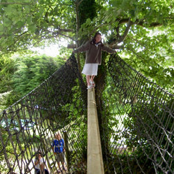 Child travels across a treetop walk at one with nature within reaching distance - Garden Playhouses