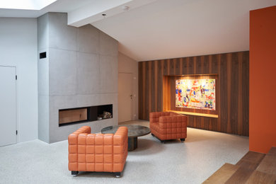 Geräumiges, Repräsentatives, Offenes Modernes Wohnzimmer mit oranger Wandfarbe, braunem Holzboden, Kamin, Kaminumrandung aus Beton und grauem Boden in München