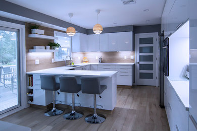 Mid-sized minimalist u-shaped porcelain tile and brown floor enclosed kitchen photo with an undermount sink, flat-panel cabinets, white cabinets, quartz countertops, brown backsplash, porcelain backsplash, stainless steel appliances, a peninsula and white countertops