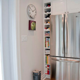 This is an example of a mid-sized country galley kitchen pantry in Ottawa with an undermount sink, recessed-panel cabinets, white cabinets, stainless steel benchtops, white splashback, stainless steel appliances, porcelain floors and multiple islands.