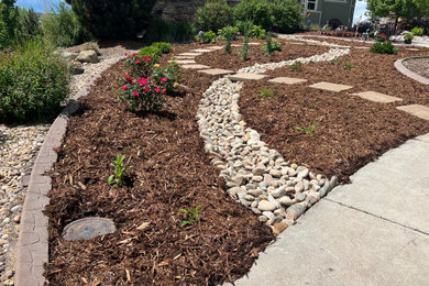 This is an example of a mid-sized modern full sun courtyard river rock landscaping in Denver.