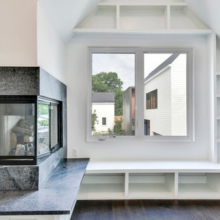 Inspiration for a small modern home office and library in Austin with a reading nook, white walls, dark hardwood flooring, a corner fireplace, a stone fireplace surround and brown floors.