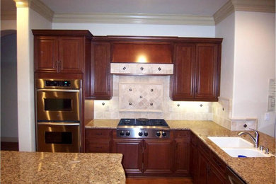 Example of a mid-sized tuscan u-shaped dark wood floor open concept kitchen design in Other with a double-bowl sink, beaded inset cabinets, dark wood cabinets, granite countertops, beige backsplash, stone tile backsplash, stainless steel appliances and an island