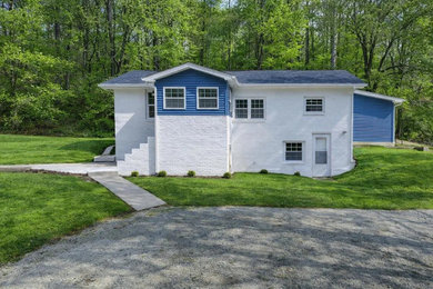 Mid-sized contemporary white two-story painted brick exterior home idea in Other with a blue roof and a shingle roof