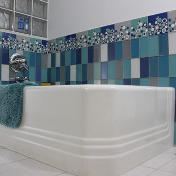 Classic corner tub with Villi glass tile wainscot wall and decorative glass bloc