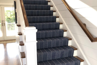 Diseño de escalera recta costera de tamaño medio con barandilla de madera, escalones enmoquetados y contrahuellas de mármol