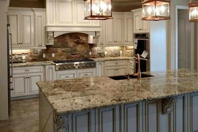 Inspiration for a mid-century modern terra-cotta tile kitchen remodel in Miami with a farmhouse sink, louvered cabinets, distressed cabinets, granite countertops, multicolored backsplash, stone tile backsplash, stainless steel appliances and an island