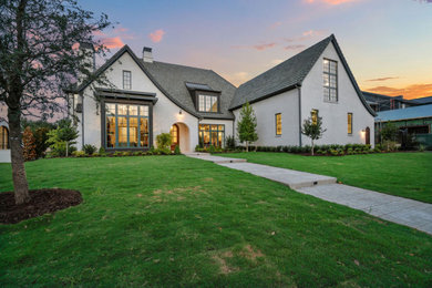Huge traditional white two-story exterior home idea in Dallas with a tile roof