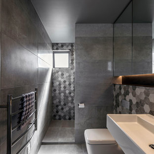 Ispirazione per una piccola stanza da bagno moderna con zona vasca/doccia separata, WC sospeso, piastrelle grigie, piastrelle in gres porcellanato, pareti grigie, pavimento in gres porcellanato, lavabo sospeso, pavimento grigio e doccia aperta