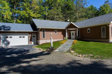 Example of a large classic brown one-story vinyl exterior home design in Other with a shingle roof