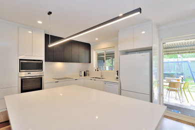 Inspiration for a mid-sized contemporary open plan kitchen in Perth with white cabinets and with island.