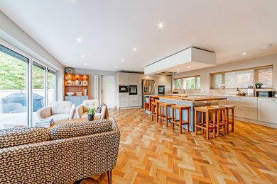 Photo of a large traditional l-shaped kitchen/diner in Kent with shaker cabinets, beige cabinets and an island.