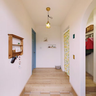 他の地域の北欧スタイルのおしゃれな玄関ホール (白い壁、テラコッタタイルの床、茶色い床) の写真