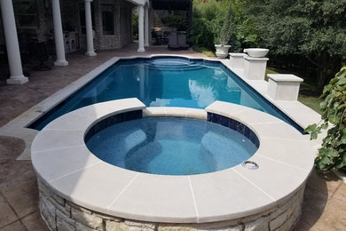 Photo of a large traditional backyard rectangular natural pool in Dallas with a water feature and tile.