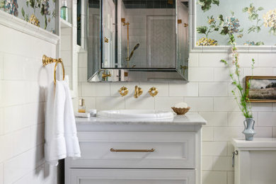 Walk-in shower - small traditional master white tile and ceramic tile ceramic tile, blue floor, single-sink and wallpaper walk-in shower idea in Chicago with recessed-panel cabinets, white cabinets, a two-piece toilet, blue walls, a vessel sink, marble countertops, a hinged shower door, gray countertops, a niche and a freestanding vanity
