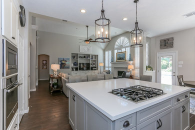 Example of a minimalist l-shaped eat-in kitchen design in Houston with beige backsplash, an island and white countertops