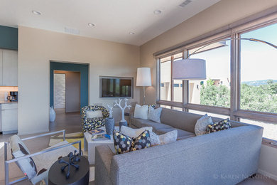 Living room - mid-sized contemporary open concept concrete floor living room idea in Albuquerque with beige walls and a media wall