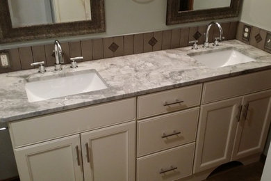 Inspiration for a 3/4 bathroom in Cleveland with an undermount sink, recessed-panel cabinets, white cabinets, granite benchtops, beige tile, ceramic tile, grey walls and medium hardwood floors.