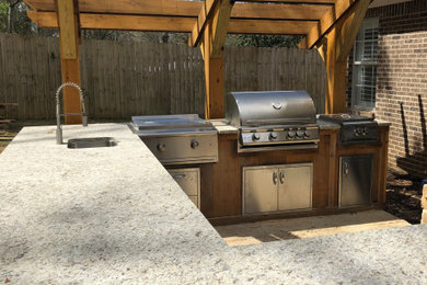 Inspiration for a large timeless backyard concrete patio kitchen remodel with a pergola