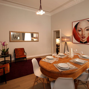 Photo of a mid-sized eclectic separate dining room in Rome with beige walls, a corner fireplace, beige floor, light hardwood floors and a plaster fireplace surround.