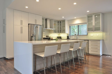 Inspiration for a mid-sized contemporary l-shaped medium tone wood floor eat-in kitchen remodel in DC Metro with a farmhouse sink, flat-panel cabinets, quartz countertops, green backsplash, glass tile backsplash, stainless steel appliances, an island and white cabinets