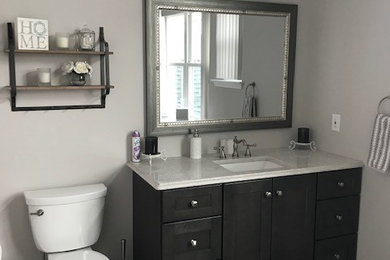 Inspiration for a transitional gray tile porcelain tile and gray floor bathroom remodel in Philadelphia with shaker cabinets, dark wood cabinets, gray walls, an undermount sink, quartz countertops and white countertops