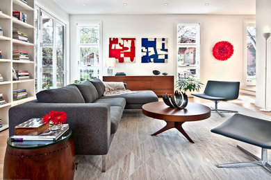 This is an example of a large contemporary open concept living room in Los Angeles with white walls and light hardwood floors.
