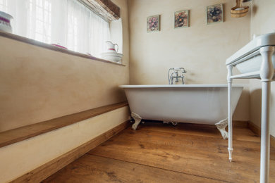 Imagen de cuarto de baño campestre con suelo de madera en tonos medios