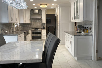 Eat-in kitchen - mid-sized contemporary u-shaped marble floor and white floor eat-in kitchen idea in Detroit with a farmhouse sink, shaker cabinets, white cabinets, granite countertops, gray backsplash, subway tile backsplash, no island and gray countertops