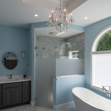 Traditional master bath utilizing frosted and clear glass to allow for needed pr