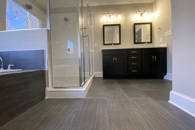 Example of a large trendy master white tile and ceramic tile ceramic tile, gray floor, double-sink and vaulted ceiling bathroom design in Charlotte with shaker cabinets, black cabinets, a two-piece toilet, gray walls, an undermount sink, quartz countertops, a hinged shower door, white countertops, a niche and a built-in vanity
