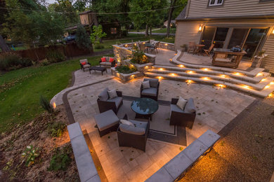 Design ideas for a large traditional backyard partial sun garden in Chicago with a retaining wall and concrete pavers.