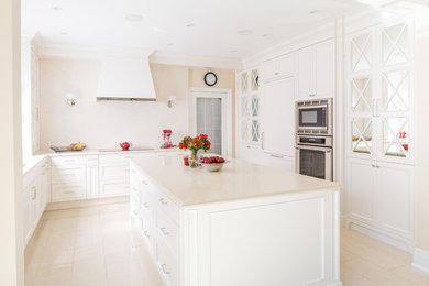 Example of a classic kitchen design in Toronto with shaker cabinets, white cabinets, stainless steel appliances and an island