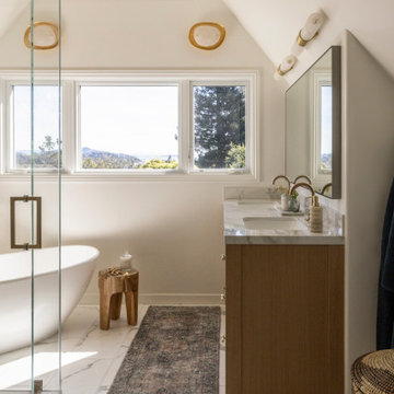 Primary Bathroom with Wood Vanity, Freestanding Tub, and Triangle Transom Window