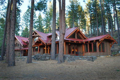 Imagen de fachada marrón de estilo americano grande de dos plantas con revestimiento de madera y tejado a dos aguas