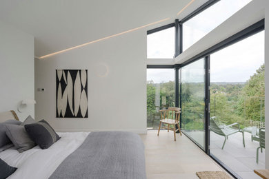 Großes Modernes Hauptschlafzimmer mit weißer Wandfarbe, hellem Holzboden und gewölbter Decke in Surrey