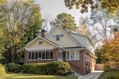Zweistöckiges Einfamilienhaus mit Faserzement-Fassade, gelber Fassadenfarbe, Satteldach, Schindeldach und grauem Dach in Atlanta