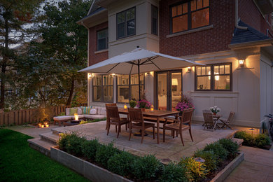 Photo of a small contemporary backyard stone landscaping in Toronto with a fire pit.