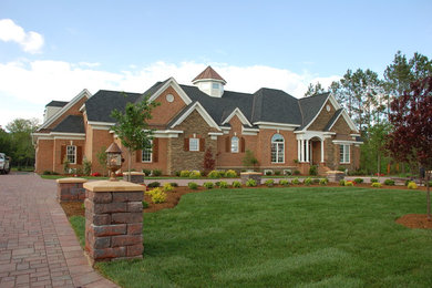 Large craftsman brown three-story brick house exterior idea in Other with a clipped gable roof