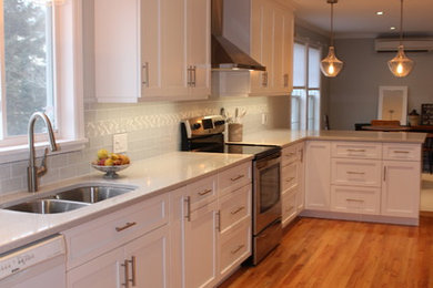 Eat-in kitchen - craftsman l-shaped medium tone wood floor eat-in kitchen idea in Other with a double-bowl sink, shaker cabinets, white cabinets, quartz countertops, gray backsplash, glass tile backsplash, stainless steel appliances, a peninsula and gray countertops