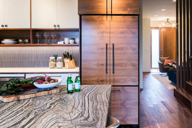 Trendy dark wood floor open concept kitchen photo in Vancouver with a farmhouse sink, flat-panel cabinets, white cabinets, granite countertops, black backsplash, ceramic backsplash, stainless steel appliances and an island