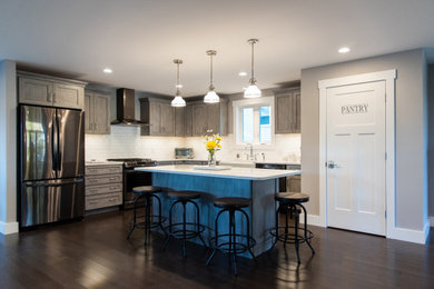 Kitchen pantry - large modern dark wood floor kitchen pantry idea in Portland Maine with a farmhouse sink, recessed-panel cabinets, light wood cabinets, quartzite countertops, white backsplash, porcelain backsplash, stainless steel appliances, an island and white countertops
