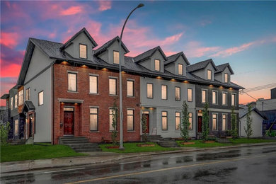 Mid-sized traditional red three-story brick townhouse exterior idea in Calgary