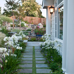 This is an example of a traditional side yard partial sun garden for spring in San Francisco with natural stone pavers and with path.